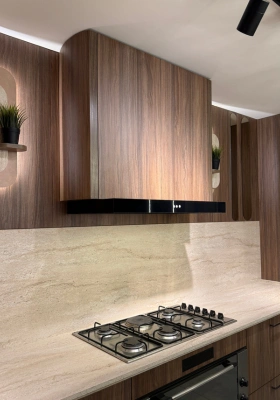 Custom walnut kitchen hood above a marble cooktop backsplash by Mr. Home
